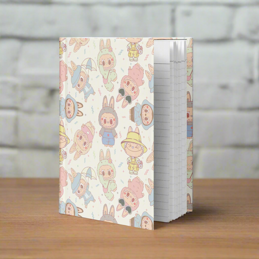 Notebook with a pastel-colored cartoon character pattern on a white background