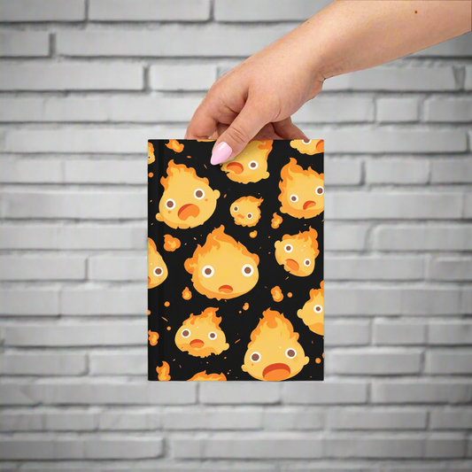 Notebook with a flame pattern held by a hand on a white background