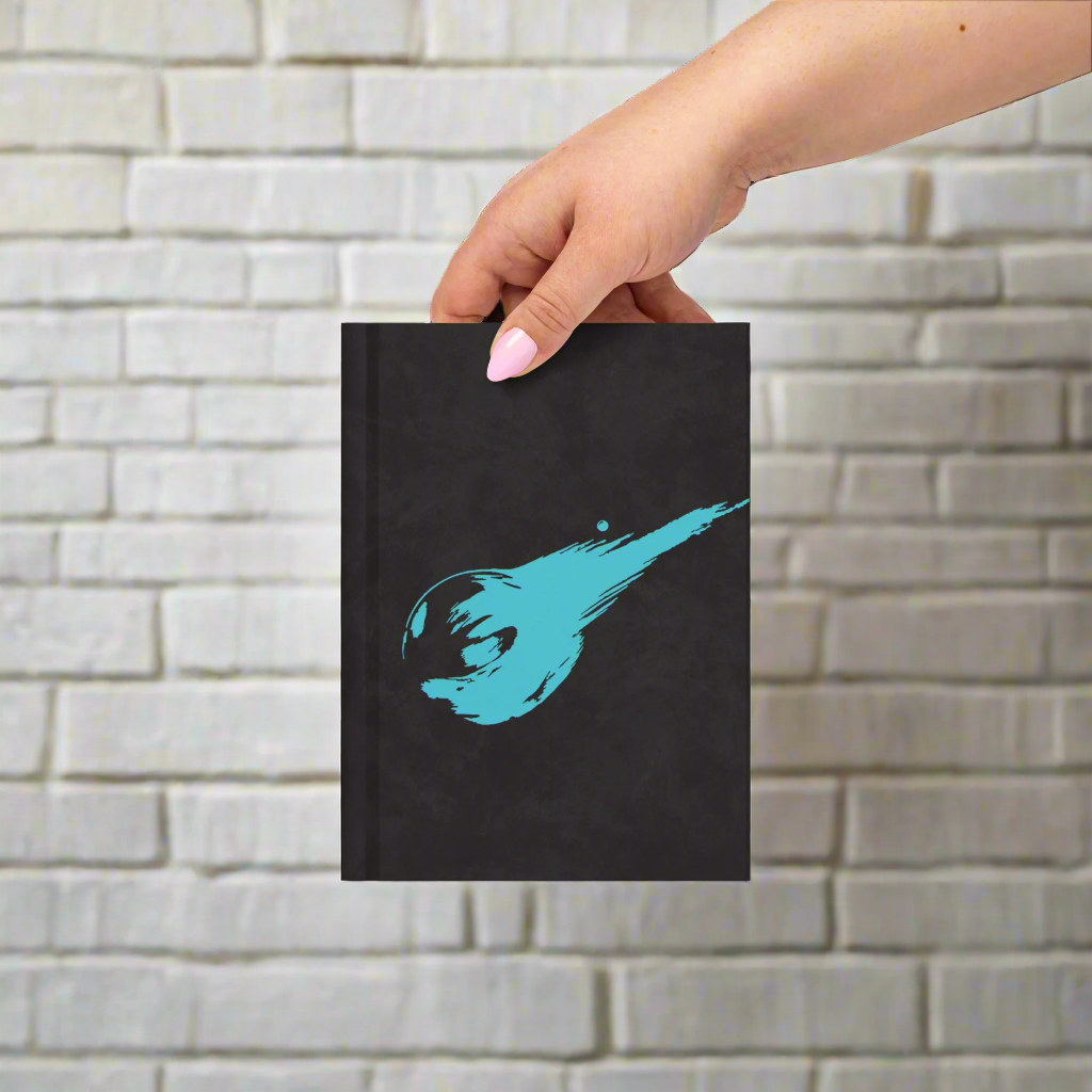 Black notebook with a blue splash design held by a hand on a white background